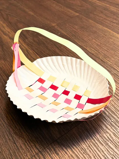 Simple materials can lead to beautiful results. This woven paper plate basket, made by one of our students, is a perfect example of the practical and creative projects we explore in our children's craft classes.