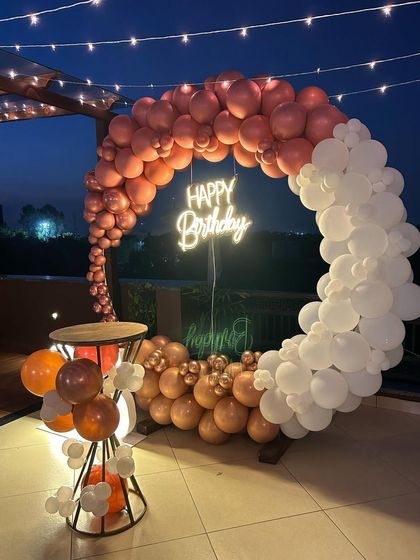 A close-up of the rose gold and white balloon ring on the rooftop, showing the details of the metallic balloons.