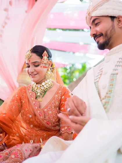 A candid moment from the wedding ceremony. The bride's makeup looks flawless and beautiful as she shares a moment with her groom.