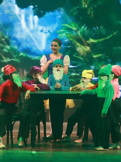 Snow White and the seven dwarfs at their dinner table. This charming scene was a favorite with the audience.