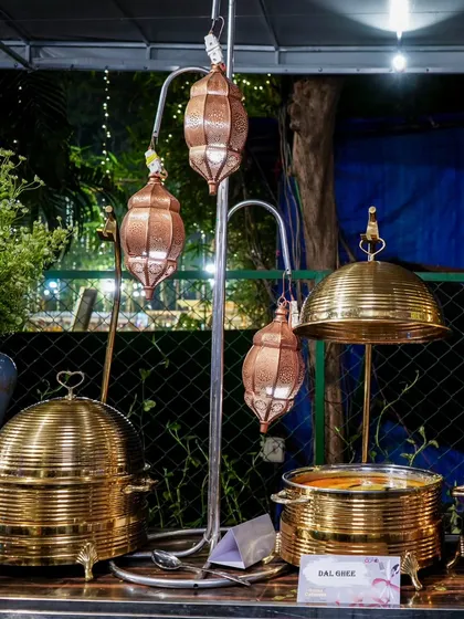 Our elegant brass serveware complemented by traditional copper lanterns, creating a warm and inviting atmosphere.