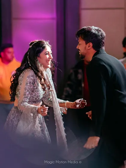A candid moment of joy between the bride and groom during their sangeet performance. We focus on creating choreography that allows for these spontaneous, happy interactions.