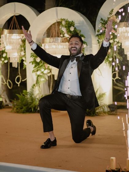 The groom's celebratory pose after a successful performance. We're your biggest hype man, ensuring you feel like a star.