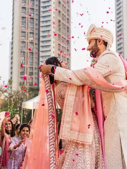 A candid moment during the varmala where the bride tripped slightly, and the groom was right there to catch her. A perfect glimpse into their supportive future.
