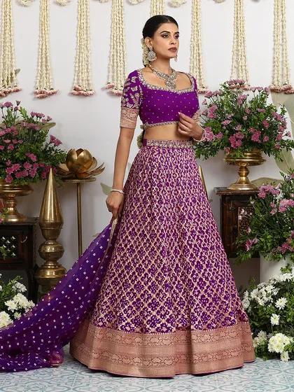 The rich brocade skirt of the purple lehenga is a testament to the ancient charm of Banarasi weaving.