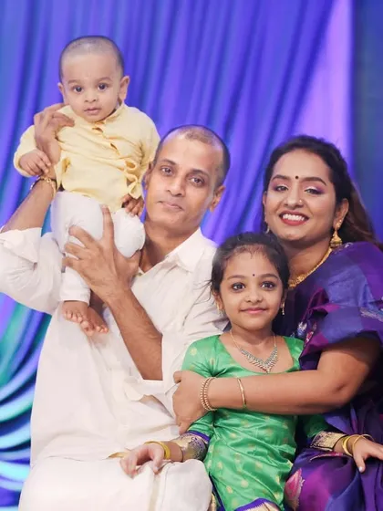 The whole family together for a traditional first birthday celebration photo. This shot includes both the baby and his proud older sister, creating a complete family memory.