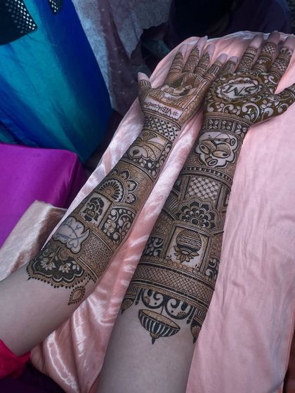 This fun design includes various personal elements requested by the bride, including a quirky cat face, a kalash, and other symbolic motifs.