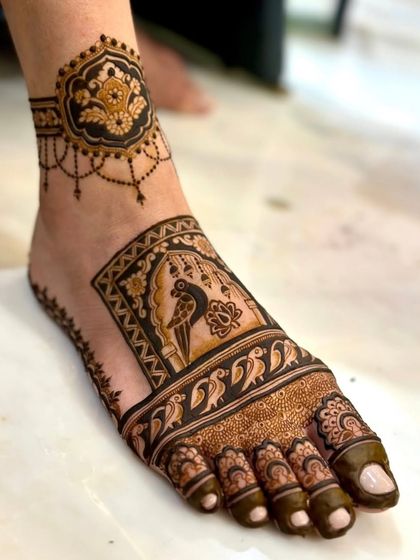 A unique foot design featuring a parrot in a jharokha (window), combining nature and architecture.