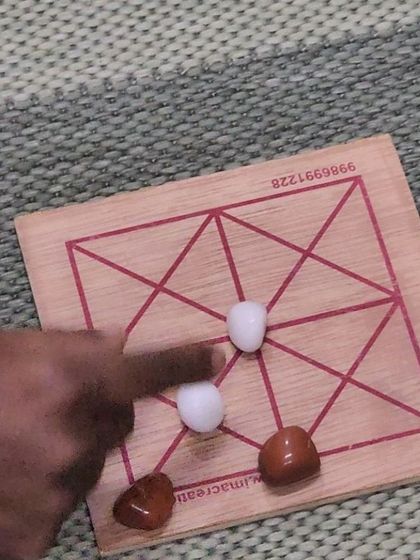 A close-up of one of the traditional board games played during our workshop. These games, which seem simple, require strategic planning and are a great way to build logical reasoning skills.