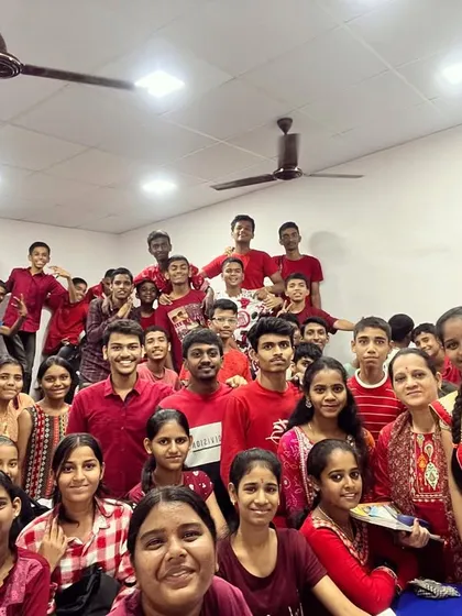 A wide shot of the classroom shows everyone participating in the red color day of Navratri 2023.