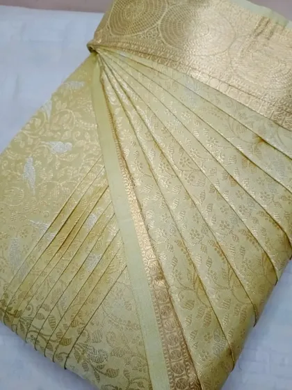 A beautiful cream-colored silk saree with a gold border.