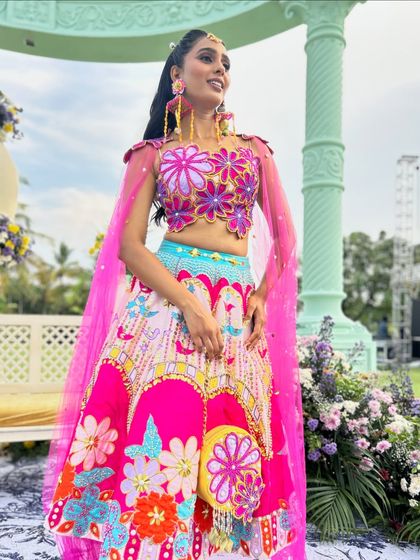 The full look, showing how the high ponytail complements the vibrant and unique lehenga.