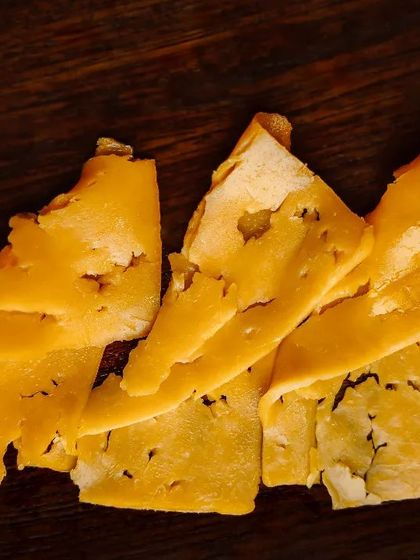 The sharp, tangy flavor of traditionally hand-made Cheddar cheese from Somerset, a key ingredient that elevates our gourmet burgers.