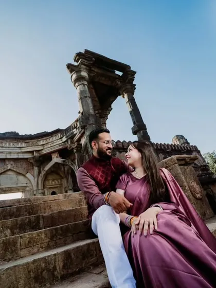 A candid moment captured on the steps of a historic monument. This relaxed pose feels natural and romantic, set against the impressive backdrop of the ruins and a clear blue sky.