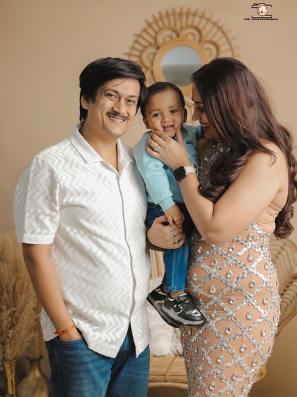 A sweet interaction where the mother gently holds her son's face. The father looks on with a smile, creating a candid family portrait that feels natural and full of affection.