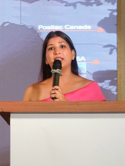 Speaking from the podium at the Kress event, with a presentation slide showing the brand's global presence in the background.