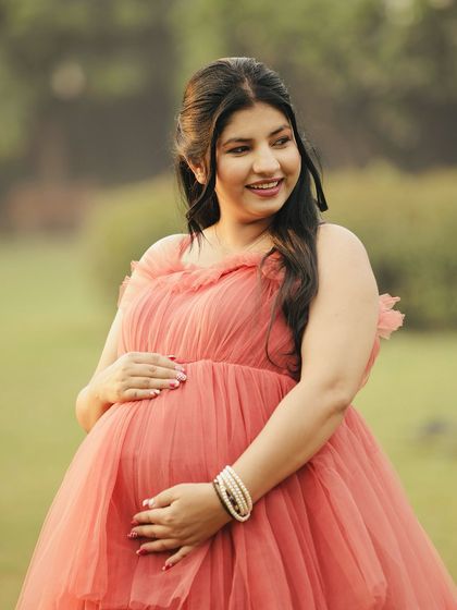 A close-up portrait of the glowing mother-to-be. The soft color of the gown complements her radiant smile perfectly.