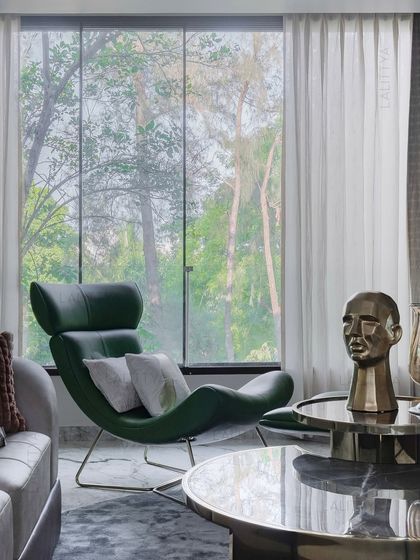 This family lounge in Chennai was imagined as a retreat. A sculptural green leather chaise invites stillness by the large window, blurring the boundary between inside and out and letting the trees become part of the decor.