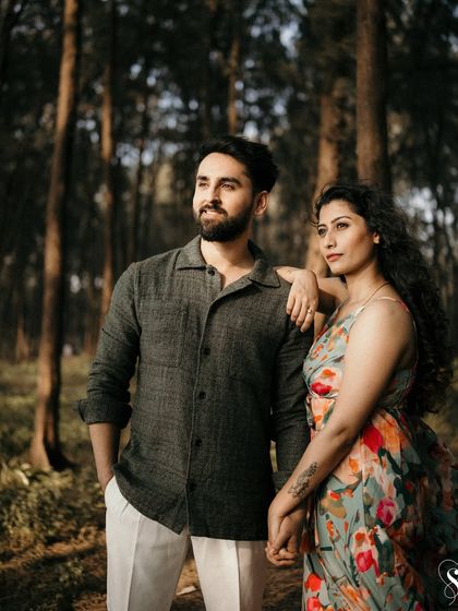 Looking towards the future, together. This candid portrait in the woods captures a moment of shared dreams and quiet confidence between the couple.
