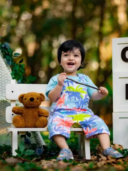 A big, happy smile from this little boy during his outdoor first birthday session. The park setting is perfect for energetic toddlers.
