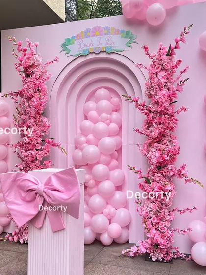 A close-up of the main backdrop for the "Pop of Pink" theme, showing the large bow detail on the pedestal.