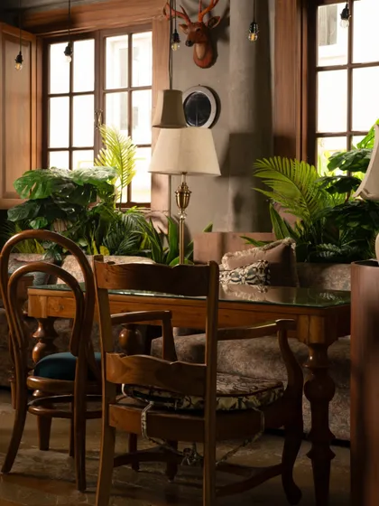 This view showcases the layered luxury of Echoes. The mix of textures, from the soft upholstery to the wooden window frames and lush plants, creates a rich sensory experience that invites guests to relax and connect.