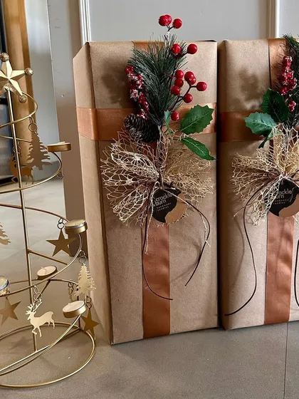 These gifts are ready to go! I used brown paper and topped them with shimmering gold bows and festive sprigs of pine and berries.