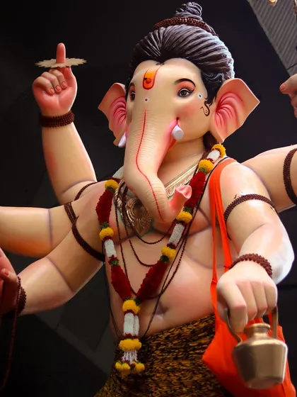 A detailed close up of a beautifully crafted Ganesh idol, highlighting the expressive features and intricate decorations.