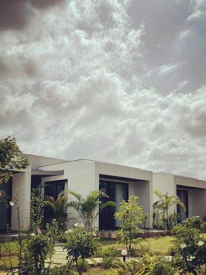 Our "Nisarg" project, with its clean lines and minimalist form, surrounded by a growing garden. The design allows each room to have a unique connection to the outdoors.