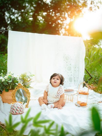 This little one is looking up with such a sweet expression during her outdoor birthday picnic photoshoot. The golden light is just magical.