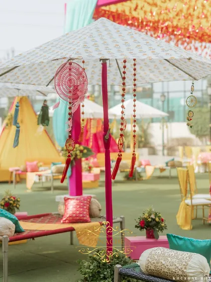 A detail shot of the decorative umbrellas, adorned with dreamcatchers and beaded hangings. These elements add texture and a bohemian flair to the poolside setting.