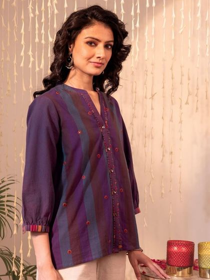 A full view of our Haveli Purple Striped Top. The vibrant cuffs and delicate embroidery make it a stylish piece that can be paired with jeans or trousers.