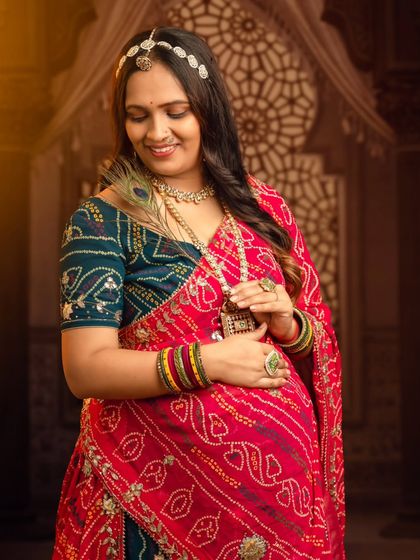 A close-up portrait of a mom-to-be in a vibrant Rajasthani bandhani saree, adorned with traditional jewelry.