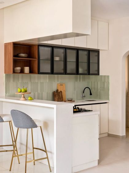 This view shows the L-shaped layout of the open kitchen, with a breakfast bar that provides extra seating and a casual dining spot.