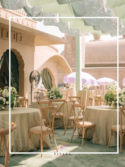 This dining table is the main character. Set under a canopy of pastel green drapes, the simple wooden chairs and floral centerpieces create a scene that is effortlessly chic.