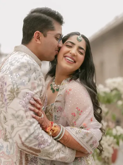 A sweet kiss on the cheek filled with genuine laughter. This photo captures the joyful, candid side of a couple's relationship amidst the grandeur of their pre-wedding shoot location.