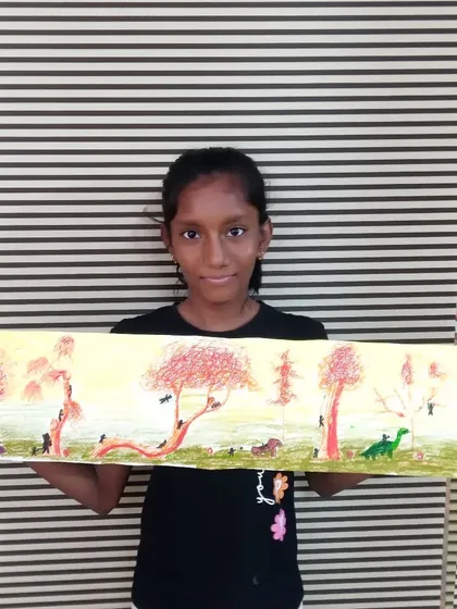Anaya, a 6th standard student, with her detailed drawing of wild animals in a forest. Her use of color creates a warm, afternoon feel in this panoramic piece.
