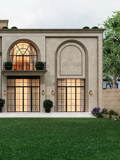 The rear facade of the classical-inspired residence, showcasing symmetrical arched windows and doors that open onto a manicured lawn. The design emphasizes rhythm and proportion.