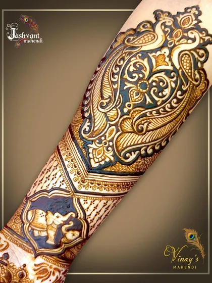 A close-up of the forearm portion of a bridal design, highlighting the intricate peacock and elephant motifs that complement the main Radha Krishna figure.