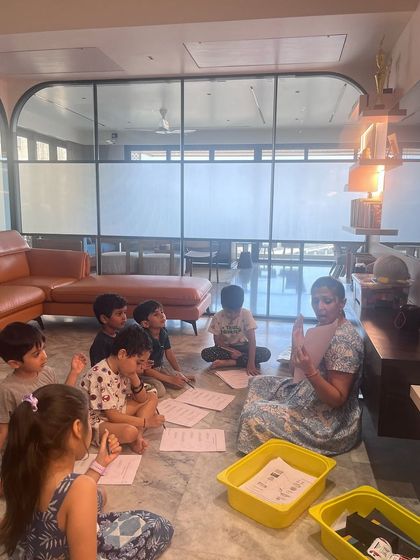 The children are gathered on the floor with worksheets after our roller coaster story. They are applying the coding logic they just learned to a fun, hands-on activity.