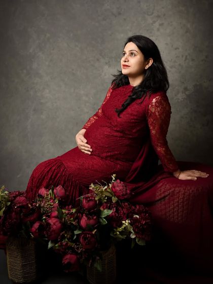 A seated pose surrounded by flowers. This setup creates a lush, romantic scene, focusing on the beauty and tranquility of the third trimester.