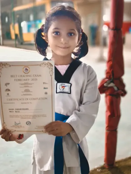 This young student proudly holds her certificate for completing her blue belt exam. Her smile says it all.
