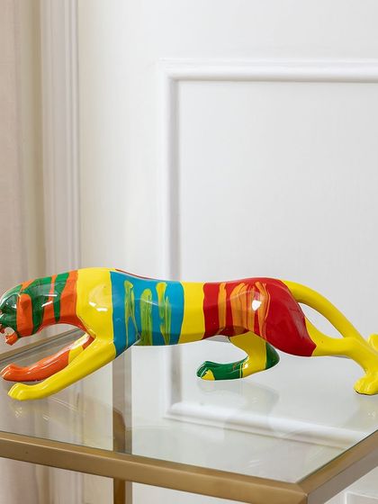 This abstract panther sculpture captures a sense of sleek movement. The body is decorated with bold, colorful stripes, making it a dynamic and artistic addition to a modern console table or glass shelf.
