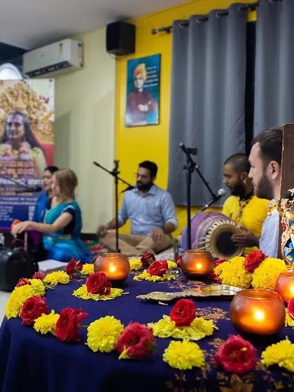 The altar setup for a kirtan event, with candles and flowers creating a sacred atmosphere for the musical gathering.