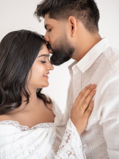 A tender forehead kiss during a couple's maternity session. These are the moments that truly tell your love story.