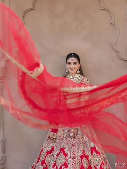 A playful moment with the dupatta. The bride's happy expression and flawless makeup create a perfect, joyful shot.