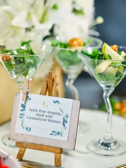 An elegant Apple Pear Arugula Salad with Caramelized Walnuts, served in a martini glass. This sophisticated salad is a refreshing and light course for any formal meal.