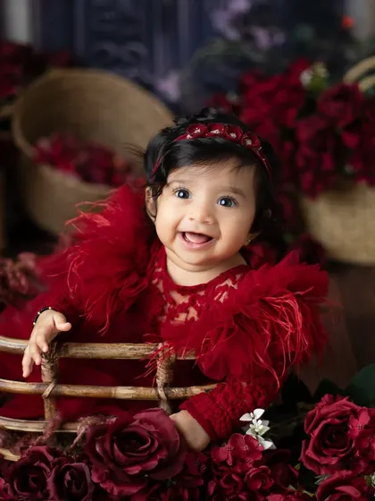 A happy smile from a basket of roses. This creative setup is both whimsical and elegant, resulting in a truly unique baby portrait.