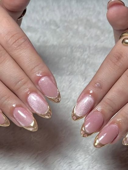 A beautifully posed shot of the pink cat eye nails with gold chrome French tips.