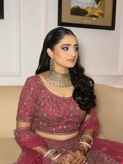Another angle of this timeless reception look. Her side profile shows off the flawless base and the soft curls in her hair, a classic choice for an elegant evening event.